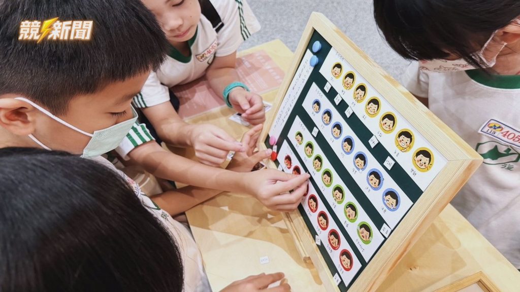 新北市府展場情緒打卡區，學童動手操作表情圖卡互動